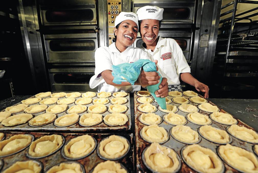 Herminia Freitas, 21, and  Abelina Da Silva-Manus, 23, learn to make  custard tarts.