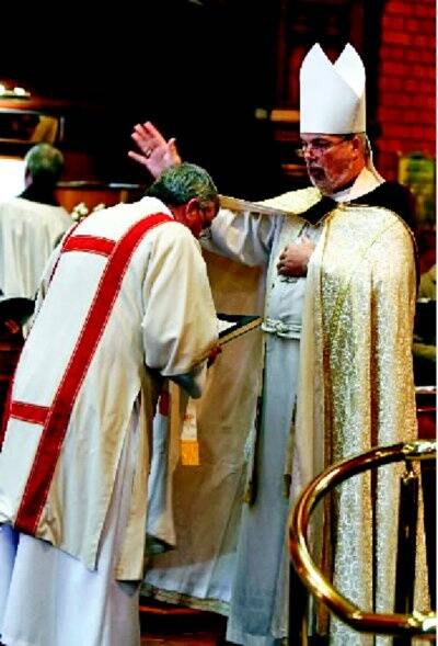 Bishop John Parkes holds the hands of Bishop Robert Beal’s widow Valerie Beal yesterday. Pictures: PETER MERKESTEYN