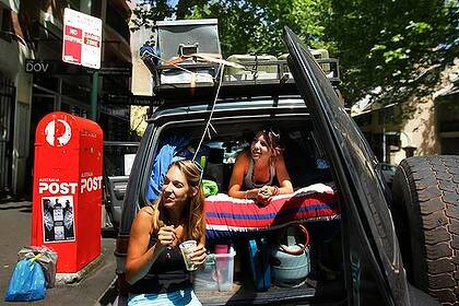 Shutting up shop … French backpackers Enora Wolf and Charline Nanot in the four-wheel drive they're trying to sell parked on Victoria Street. They bought it three months ago from the same spot.