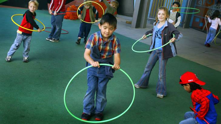 Children enjoy playing with hula hoops in the playground of the Melbourne Museum. Photo: Simon O'Dwyer
