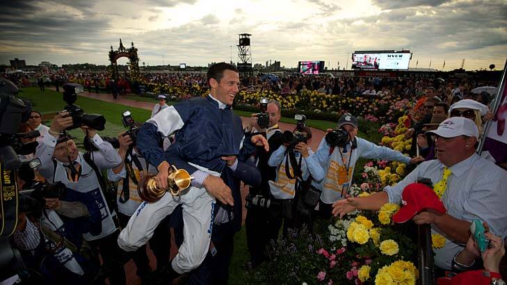 Moment of glory ... Nick Williams, owner of Green Moon, picks up jockey Brett Pebble after he stormed home to take out the Melbourne Cup yesterday.