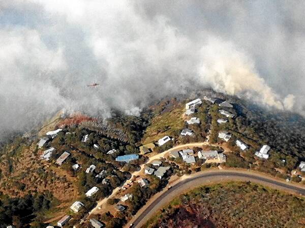 Fires surround lodges and chalets at Mount Hotham on Saturday afternoon as helicopters work to keep the fire at bay