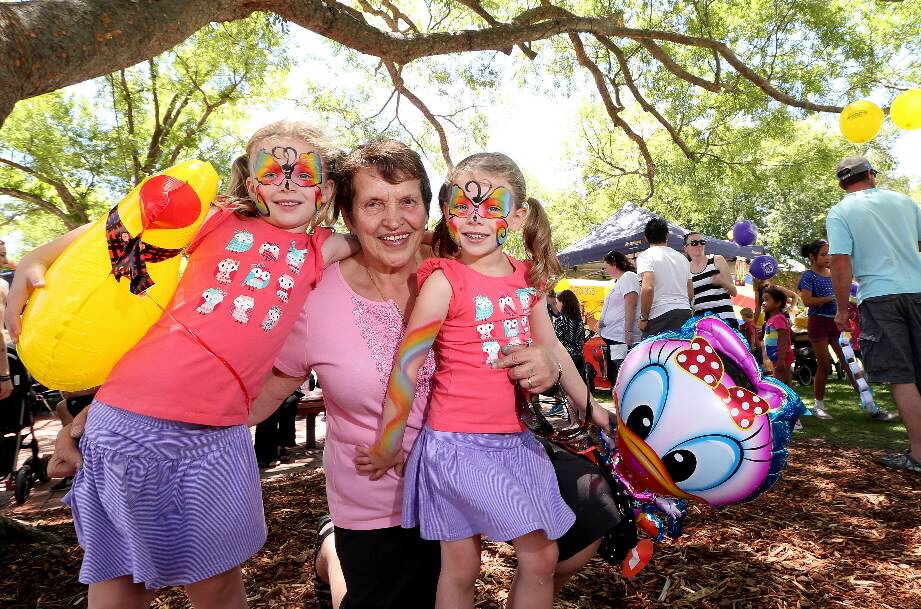 Twins Olivia and Charlotte Mlinaric enjoy the Christmas family fun day in Albury on Saturday with their grandmother Milka Mlinaric. Pictures: JOHN RUSSELL