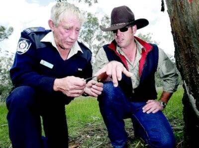 Lionel Smith and Sen-Constable Scott Barton inspect arrow tips dug from a tree. Picture: JOHN RUSSELL