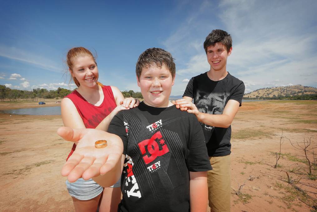 Aidan Allan, with siblings Ashleigh and Matt Allan, shows the ring inscribed with the date 11-12, the same date as his 12th birthday. Picture: TARA GOONAN