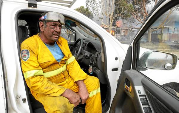 Tony Halpin sits in his ute, his house burning behind him.