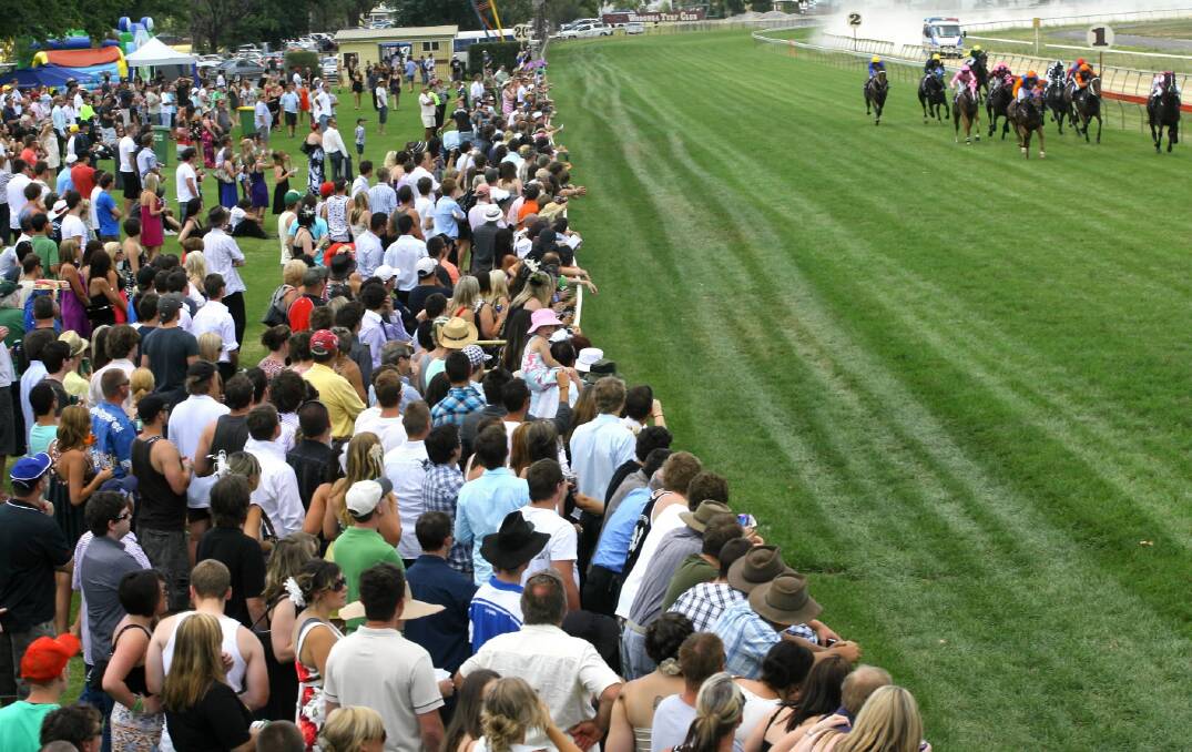 Here they come... a typical big crowd watches a Wodonga Boxing Day race. This year a deck will be built for the public on the home straight.