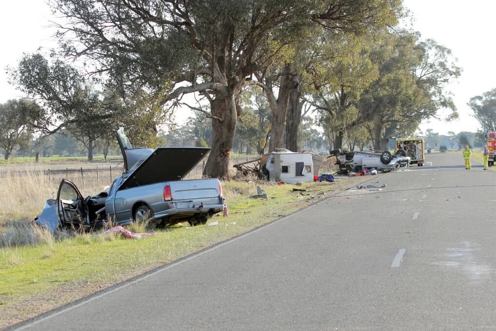 The dead woman’s silver Ford utility lies beside the road with caravan and four-wheel- drive in the distance. Picture: TARA GOONAN