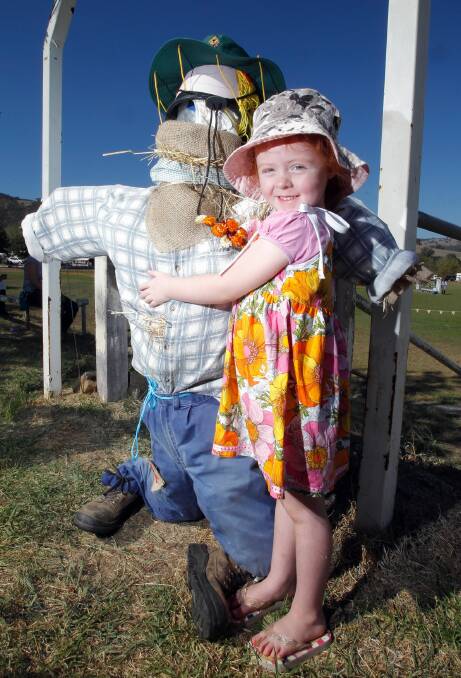 Alice Bowen, 4, from Tallangatta gives a hug to Scarecrow Farmer Joe.