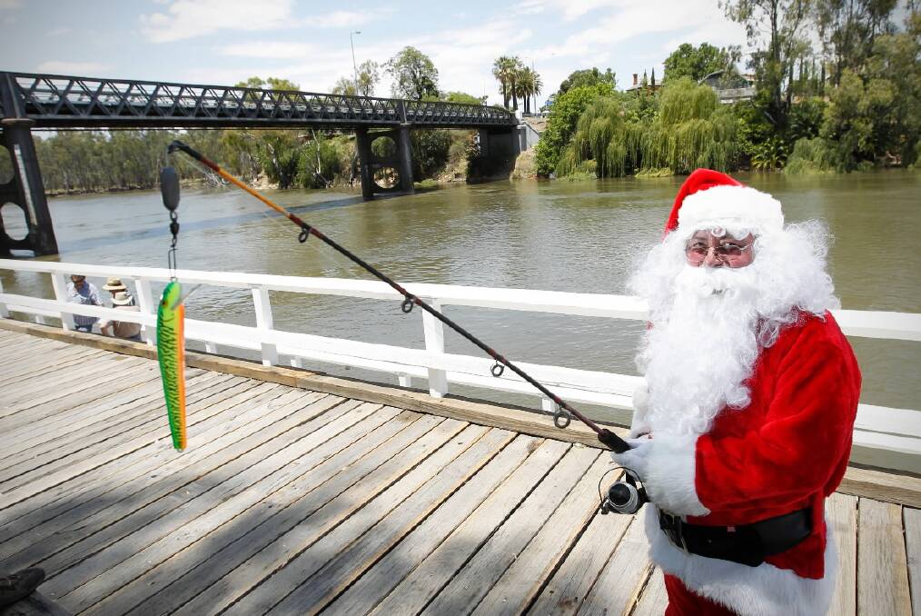 Santa tries his hand with a rod at the new platform opened at Rowers Park yesterday. Picture: BEN EYLES