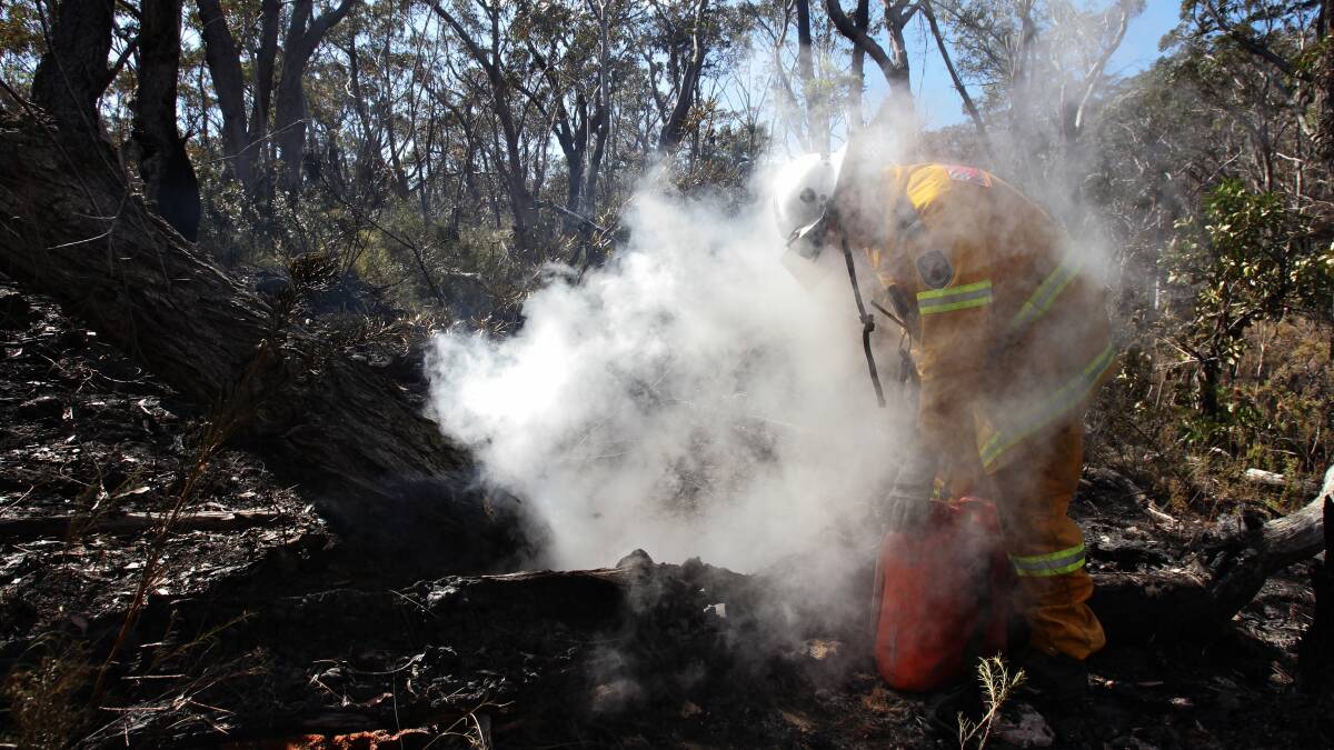 Tim Parsley from from Wentworth Falls RFS mopping up after a backburn west of Hat Hill Rd in Blackheath in preparation for worsening conditions today. Photo: DALLAS KILPONEN