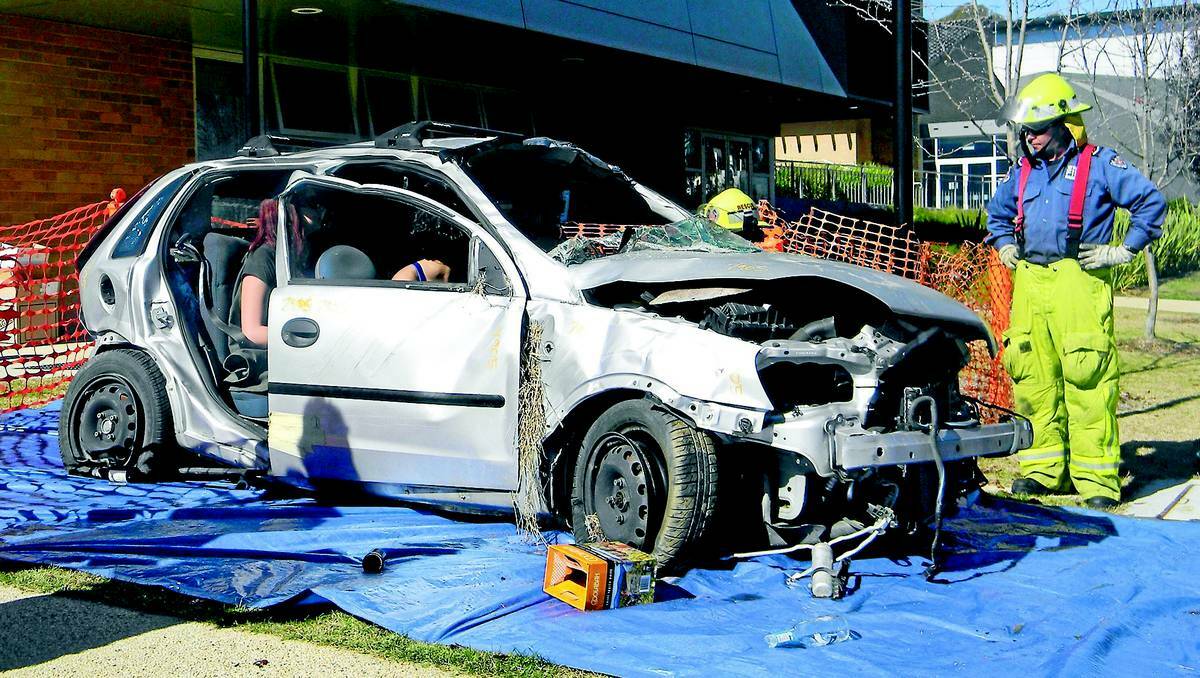 Charles Sturt University students in Orange in the wreck of a mangled car as firefighter Chris Sanders talks of the dangers of drink-driving.