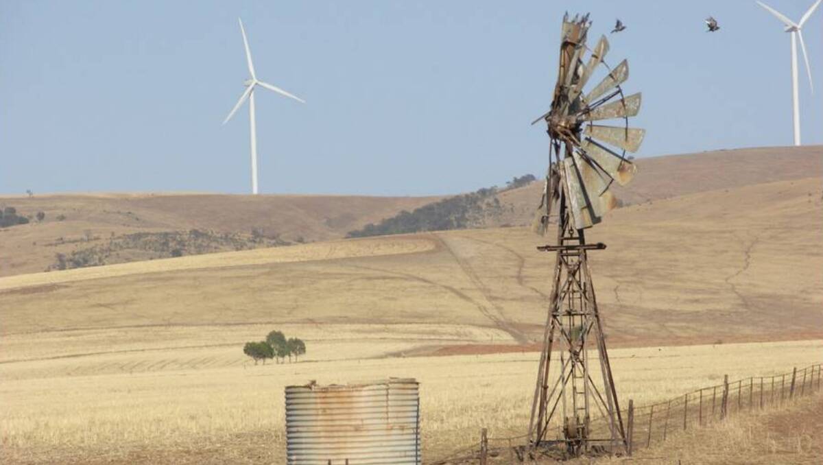 A contrast of old and new, with a windmill pictured in front of wind turbines near Redhill in South Australia.