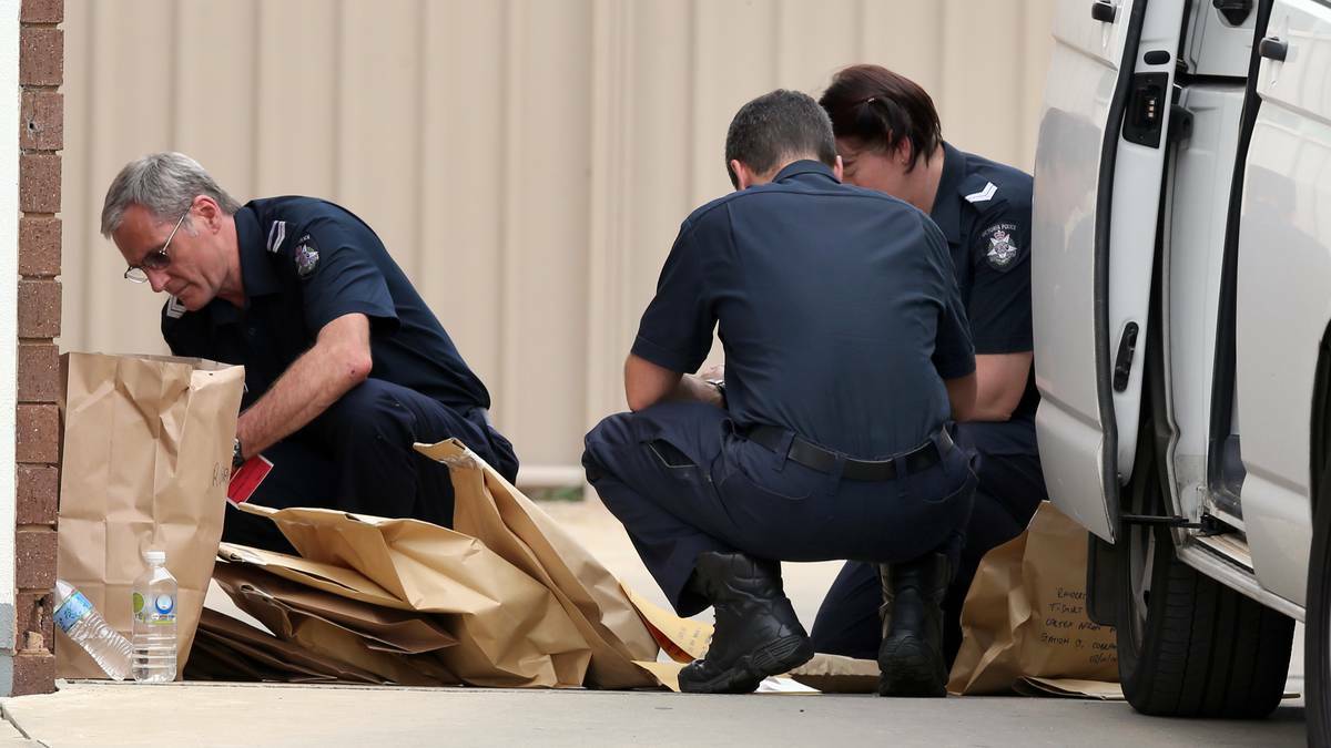 Police organise evidence bags outside the service station in Cobram where Hayden Atkinson-Thring, 20, was stabbed to death on Thursday.