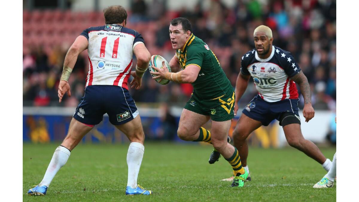Paul Gallen (C) of Australia cuts between Clint Newton (L) and Eddy Pettybourne (R) of USA during the Rugby League World Cup Quarter Final match between Australia and the USA. Photo: Getty Images.