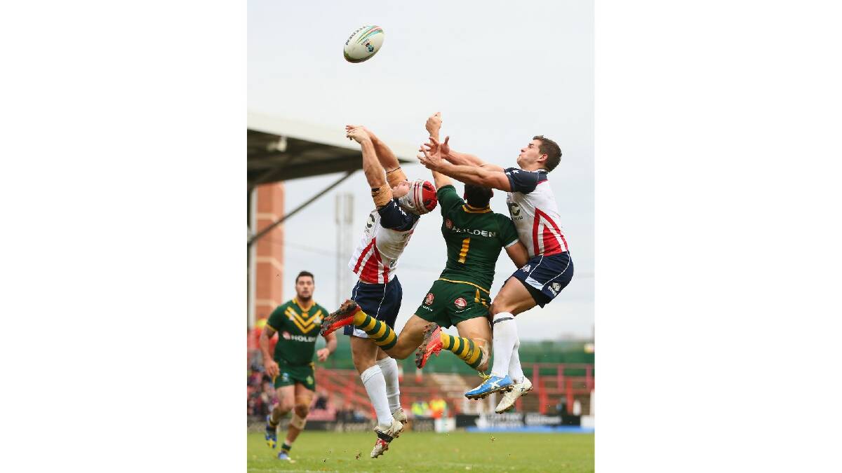 Billy Slater (2R) of Australia leaps for a high ball with Craig Priestly (L) and Taylor Welch (R) of USA during the Rugby League World Cup Quarter Final match between Australia and the USA. Photo: Getty Images.