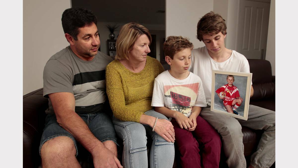 Joe and Belinda Caruso and sons Bayley, 10, and Nicholas, 16, remember 13-year-old Josh – in the picture frame – who died while walking to school. Picture: Jonathan Carroll