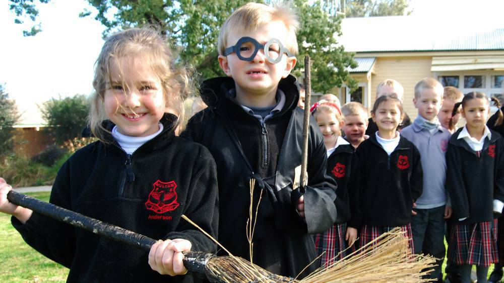 COWRA: Mulyan Public School students Cailee Anderson and Digby McGregor pose as Hermione Granger and Harry Potter watched by fellow kinders