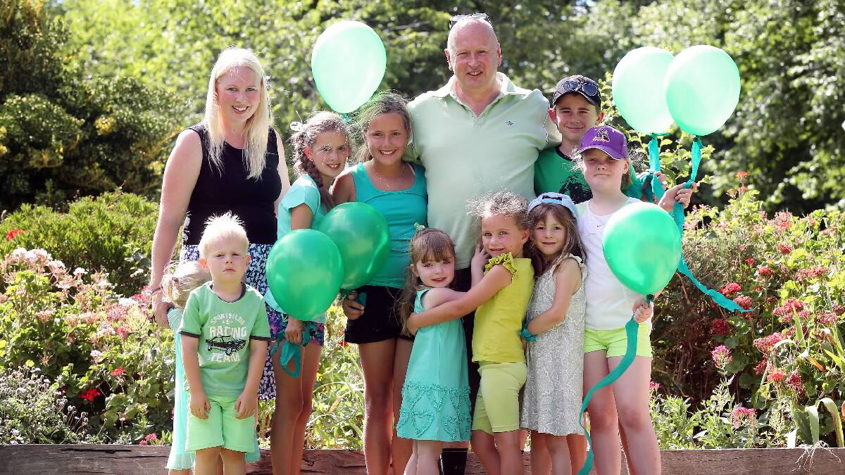 Peter Knight stands surrounded by some of the many children of Howlong that came under the care of his late wife Sue, who passed away on Monday after a brief fight with cancer. Picture: JOHN RUSSELL