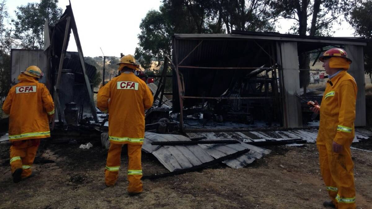 Wodonga CFA crew members attend the clean up of a shed fire in Leneva yesterday. Picture: BRETT MYERS