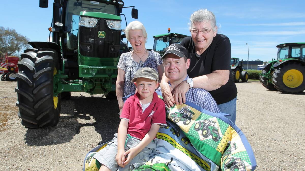 Lyn Jacobsen lets Darren Shearer try out her John Deere quilt as his son Conrad, 5, and mother Janel Shearer look on. Picture: DAVID THORPE
