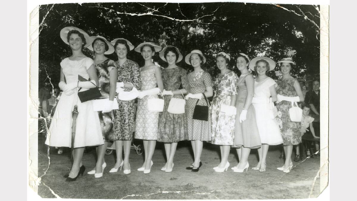 Group portrait of the 10 Floral Festival Queen candidates for 1959, including Heather Faulkhead (now Heinjus) at left and 1959 crowned queen Coral Hague (now Close) 5th from right, at the Botanic Gardens wearing day dresses with heels, handbags, glaves and hats for the Floral Festival opening garden party. Picture: ALBURYCITY COLLECTION