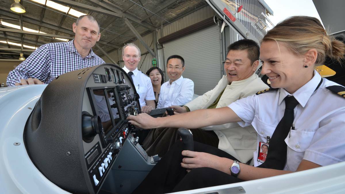 Port Macquarie mayor Peter Besseling, chief pilot Kevin McMurtrie, Arena International Aviation’s Li Li, Tian Wei from Hainan Airlines Group, Arena International Aviation chairman Li Chunming and flight instructor Ashlee Hayes inspect one of the new Diamond aircraft.