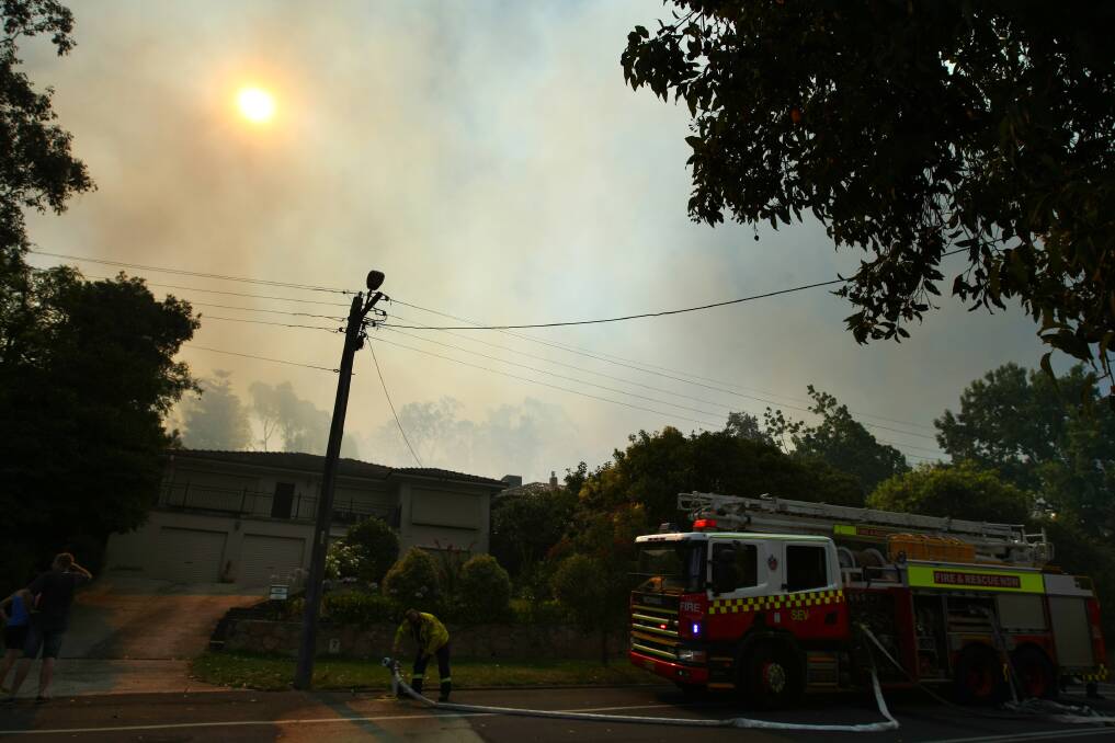 Smoke billows from behind Yambla Street homes after a fire broke out on Nail Can Hill on Tuesday. PICTURE: Matthew Smithwick.