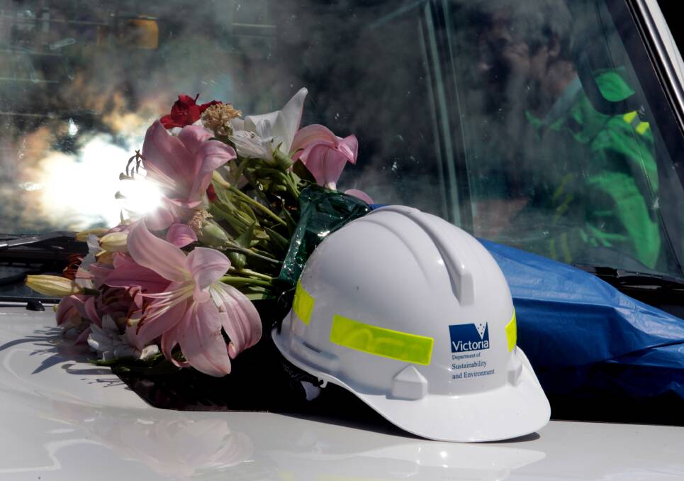 Flowers, Mr Kadar’s overalls and helmet were laid on a DSE truck at the front of the hall. Picture: PETER MERKESTEYN