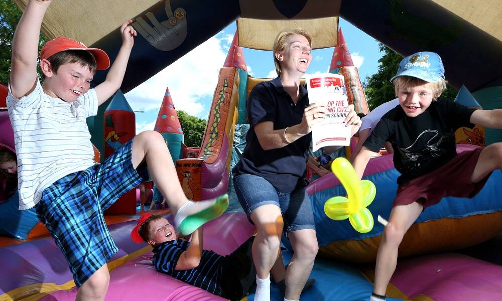 Lisa Denton, from Burrumbuttock, a teacher and a parent, has her say at the teachers and TAFE staff family day while sons Jeremy, 10, left, and Matt, 7, right, and Jayden Cropper, 10, from Lavington enjoy themselves. PICTURE: Kylie Esler.