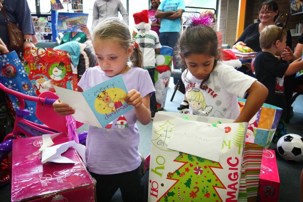 Natayla Richards and Aliyah Siddique open their Christmas presents sent by the students of Castle Hill High School in Sydney. 