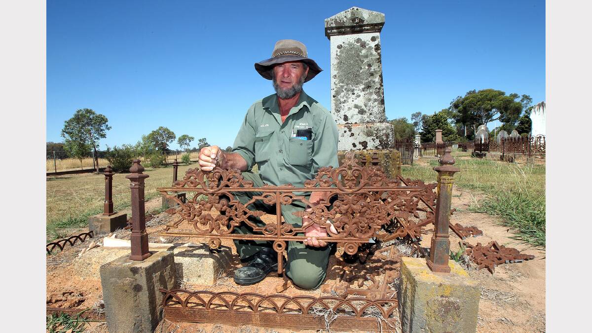 Cemetery caretaker, Kelvin Sexton with a smashed iron fence of a very old unmarked grave.