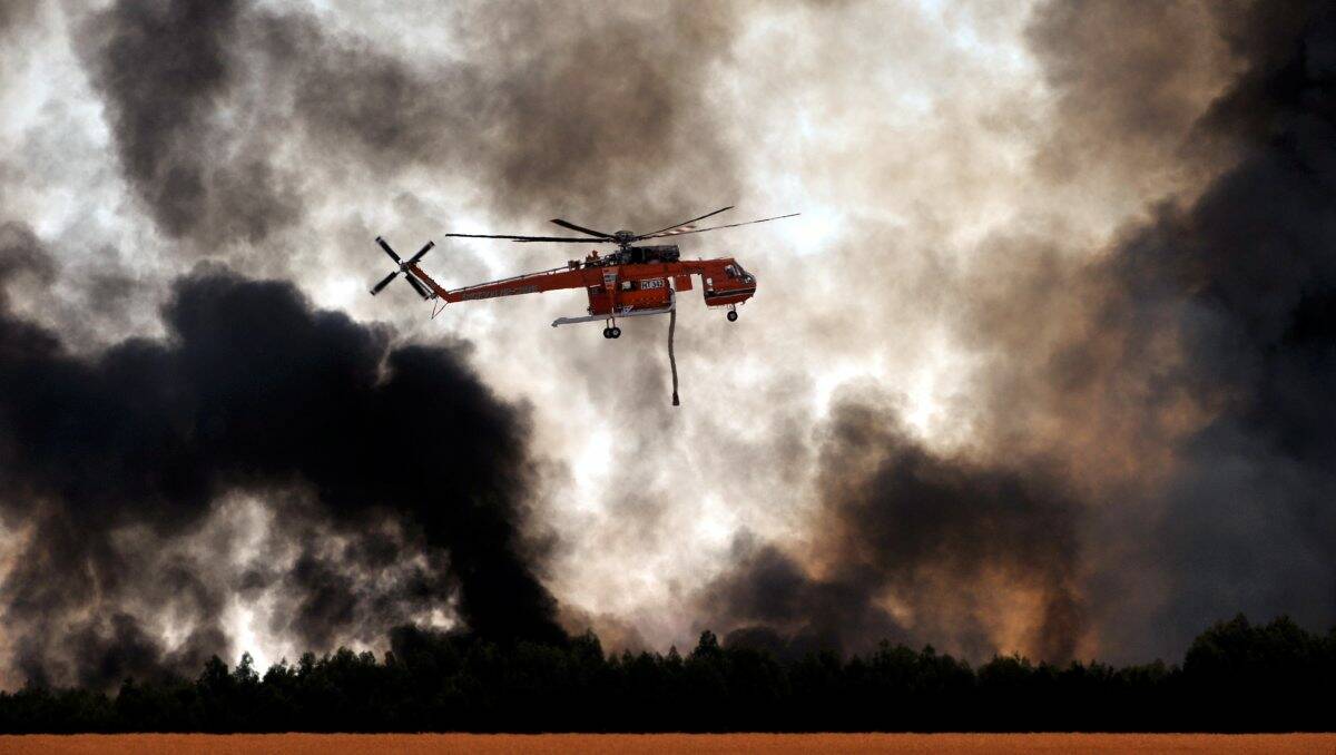 Firefighters battle a blaze from the air in a blue gum plantation near Carngham yesterday, which was contained last night. PICTURE: JEREMY BANNISTER 