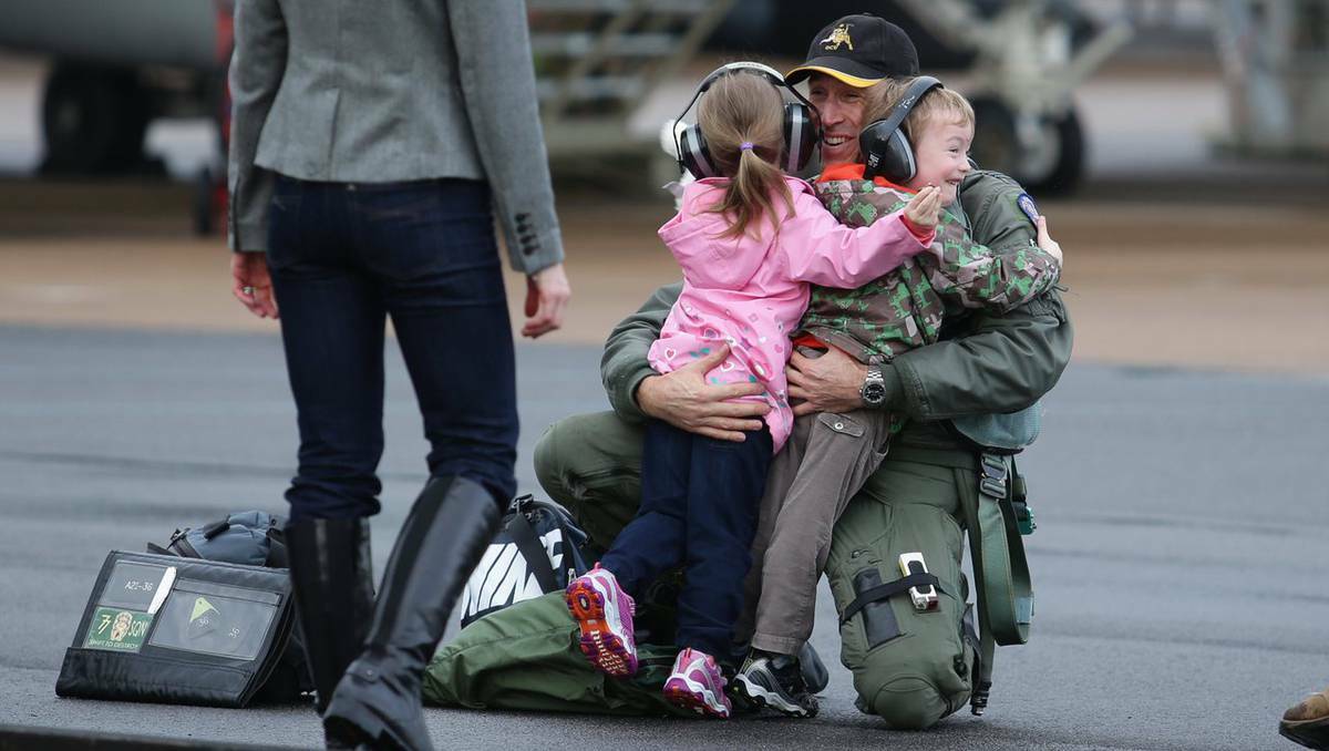 RAAF pilots are reunited with loved ones after being away for four weeks on the Aces North exercise, the final part of a five-month training course. Wing Commander Matthew McCormack greeted by 3yr old twins Benjamin and Sophie and wife Ariane. Picture: Peter Stoop