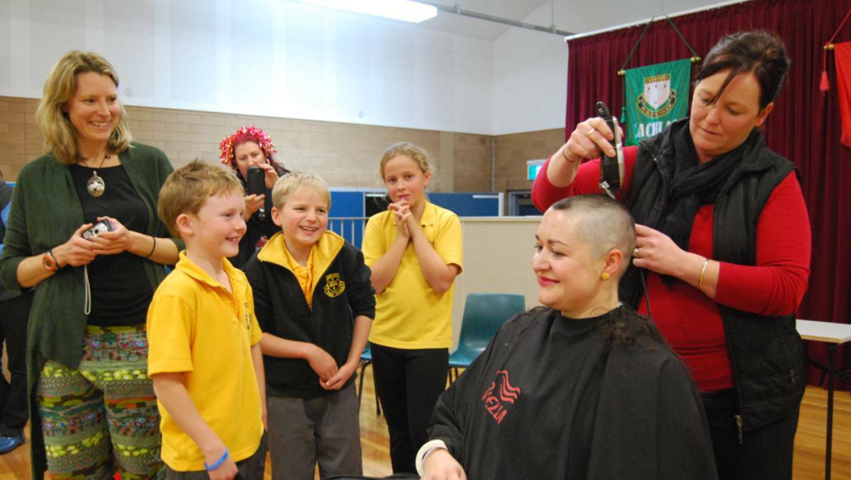 CANOWINDRA: Hairdresser Kylie Lawrence shaves Canowindra Public School teacher Jess Swords' head as Peta Laurie, Cayless Dunn, Shani Nottingham, Dustan Smith and Ellie Giger watch. The fundraising effort will see $2300 donated to cancer care. Picture: Central Western Daily
