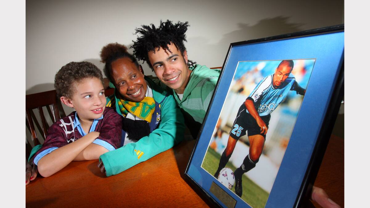 Dre Deery, 8, looks on at a picture of his uncle Archie Thompson with Archie's mother Esther Thompson and brother Marty, 18. (2008)