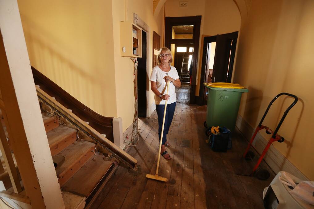 Mrs Ling at the foot of the staircase that was damaged by water. 