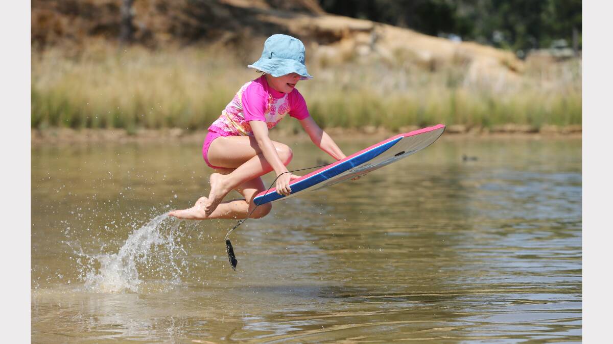 Clare Martinae, 7, takes a flying leap into the waters of Lake Sampbell, at Beechworth. 