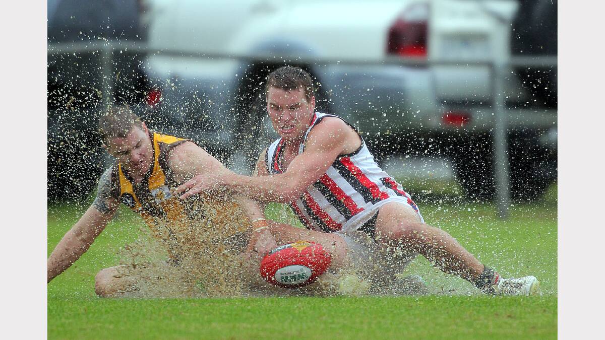 Jamie Wolf and Josh Lieschke battle through the wet in the Kiewa Sandy Creek vs Wodonga Saints match. Picture: TARA GOONAN