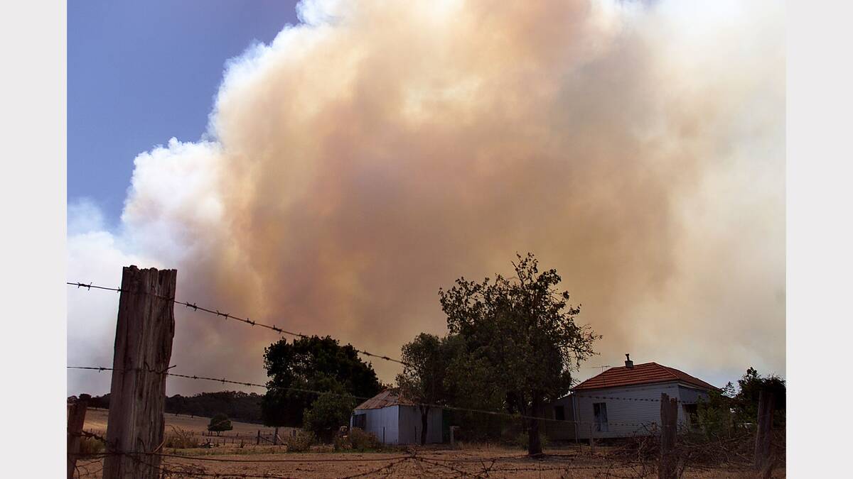 2003 January - Smoke from the Eldorado fire looms over a house on the Chiltern-Beechworth Road.