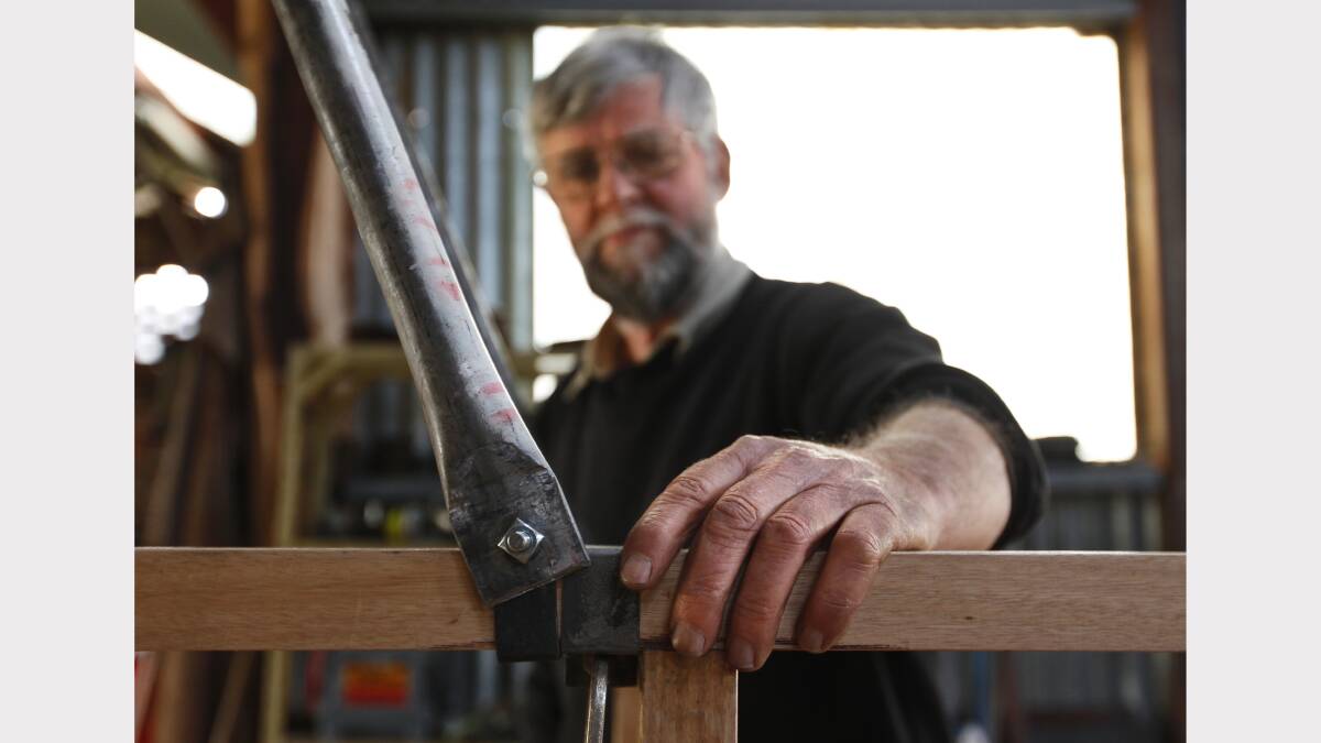 3. Blacksmith Max Bowran with a installed bracket on the framework of the replica plane. Picture: BEN EYLES