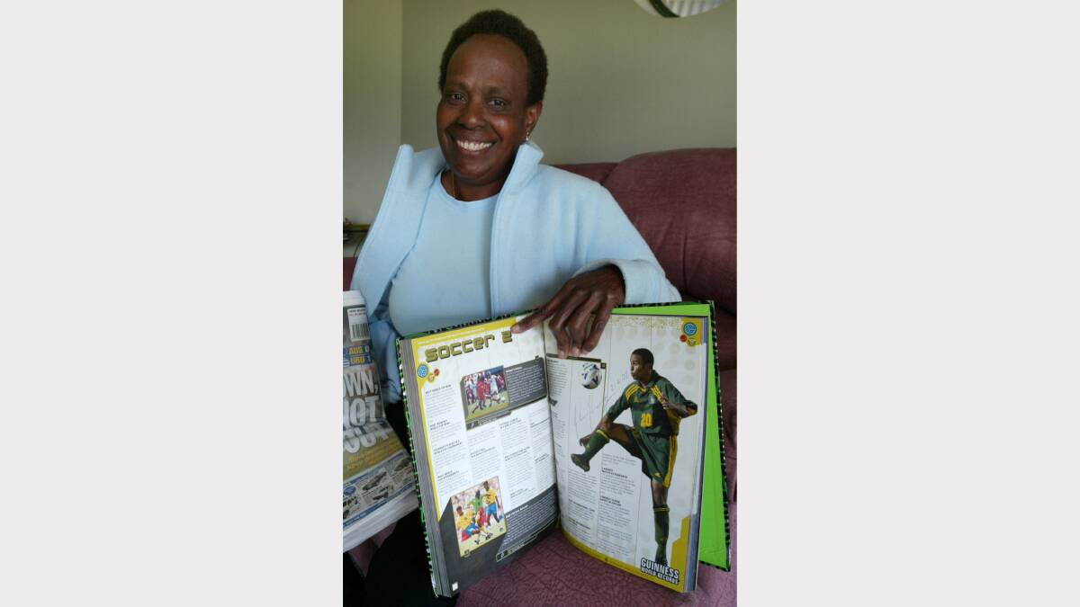 Archie Thompson's mother Esther Thompson with a photo of him in the Guiness Book of Records.