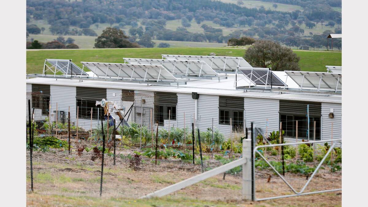  A view over the facility showing solar panels and a vegetable garden in the foreground.