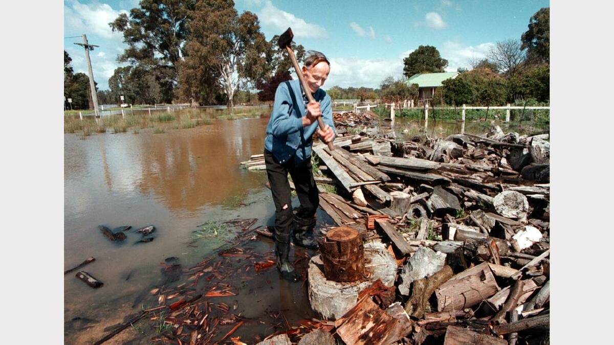 Joe Williamson still shops his wood for the fire as flood waters continue to rise. Picture: PETER MERKESTEYN