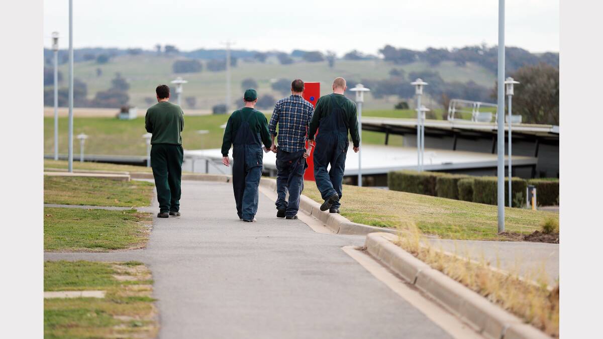 A group of inmates walk together after the gangs come back from a days work.