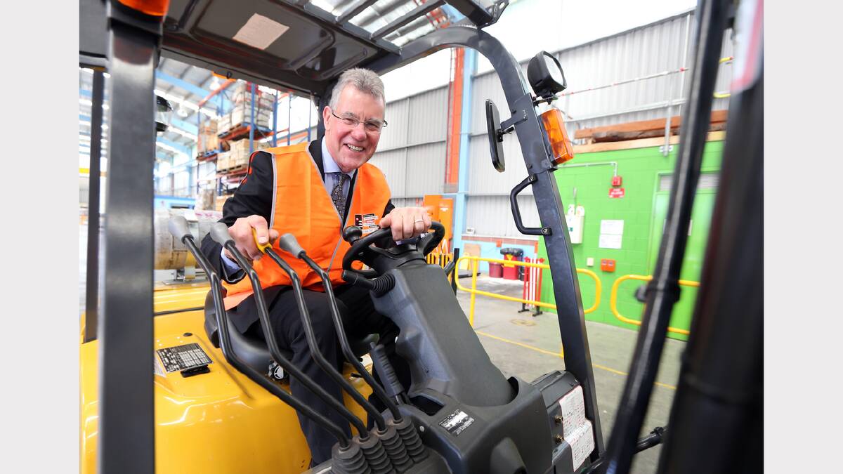 Minister for Higher Education and Skills Peter Hall has a test run on the forklift. 