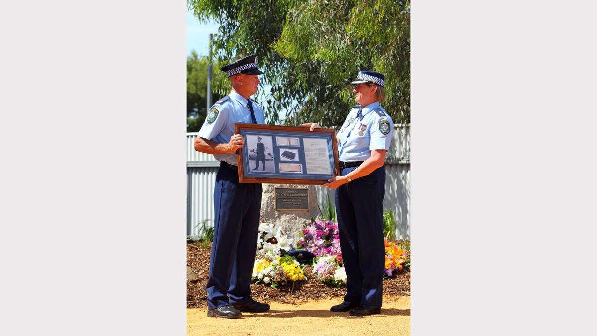Sen-constable Greg Pettigrew is presented with a framed memorial of Sgt Cyril Howe by Supt. Beth Stirton. 