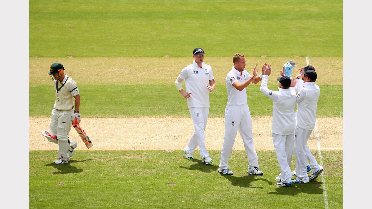 England's Stuart Broad  is congratulated by team mates after taking the wicket of Australia's David Warner.