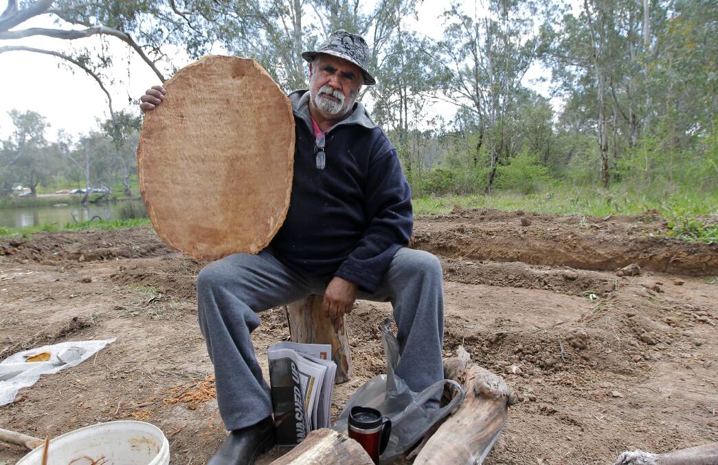  Elder Ray kennedy holds the Coolamon that was carved from the tree before the canoe.
