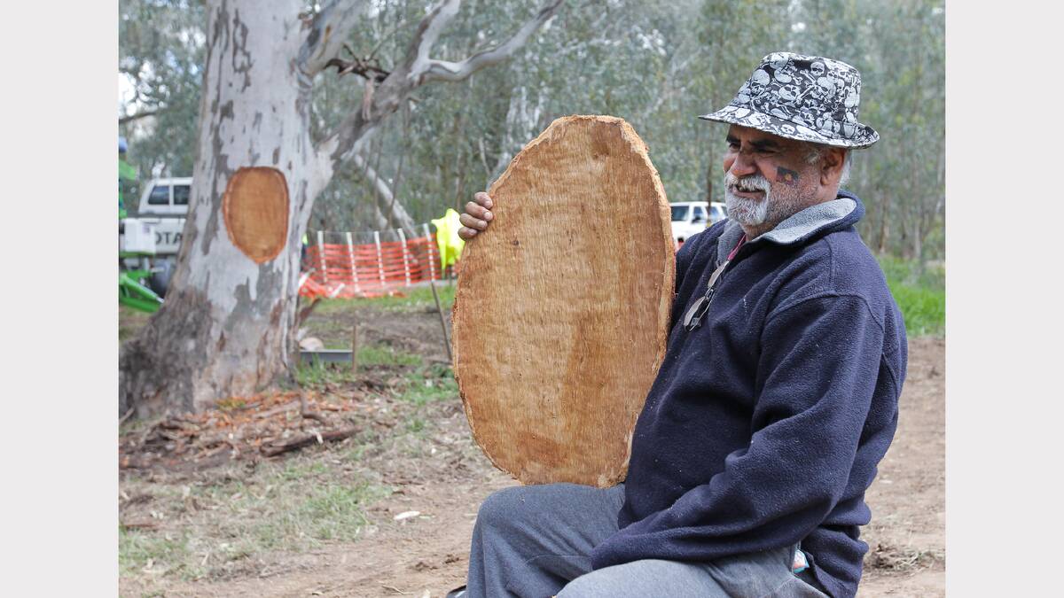 Elder Ray kennedy holds the Coolamon that was carved from the tree before the canoe.
